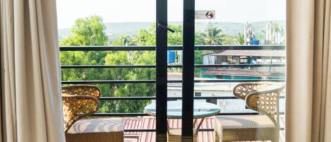 A room with a sliding glass door leading to an outdoor area with a table and chairs.