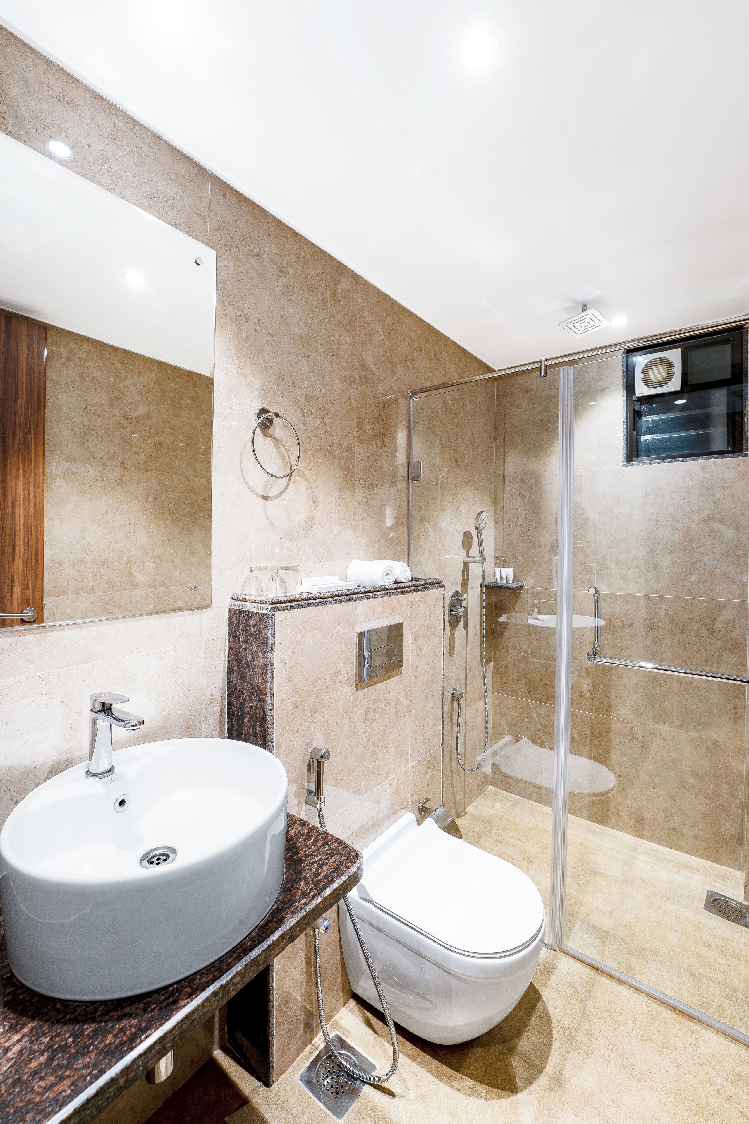 Une salle de bain moderne avec un lavabo blanc, des toilettes et une douche à parois de verre.