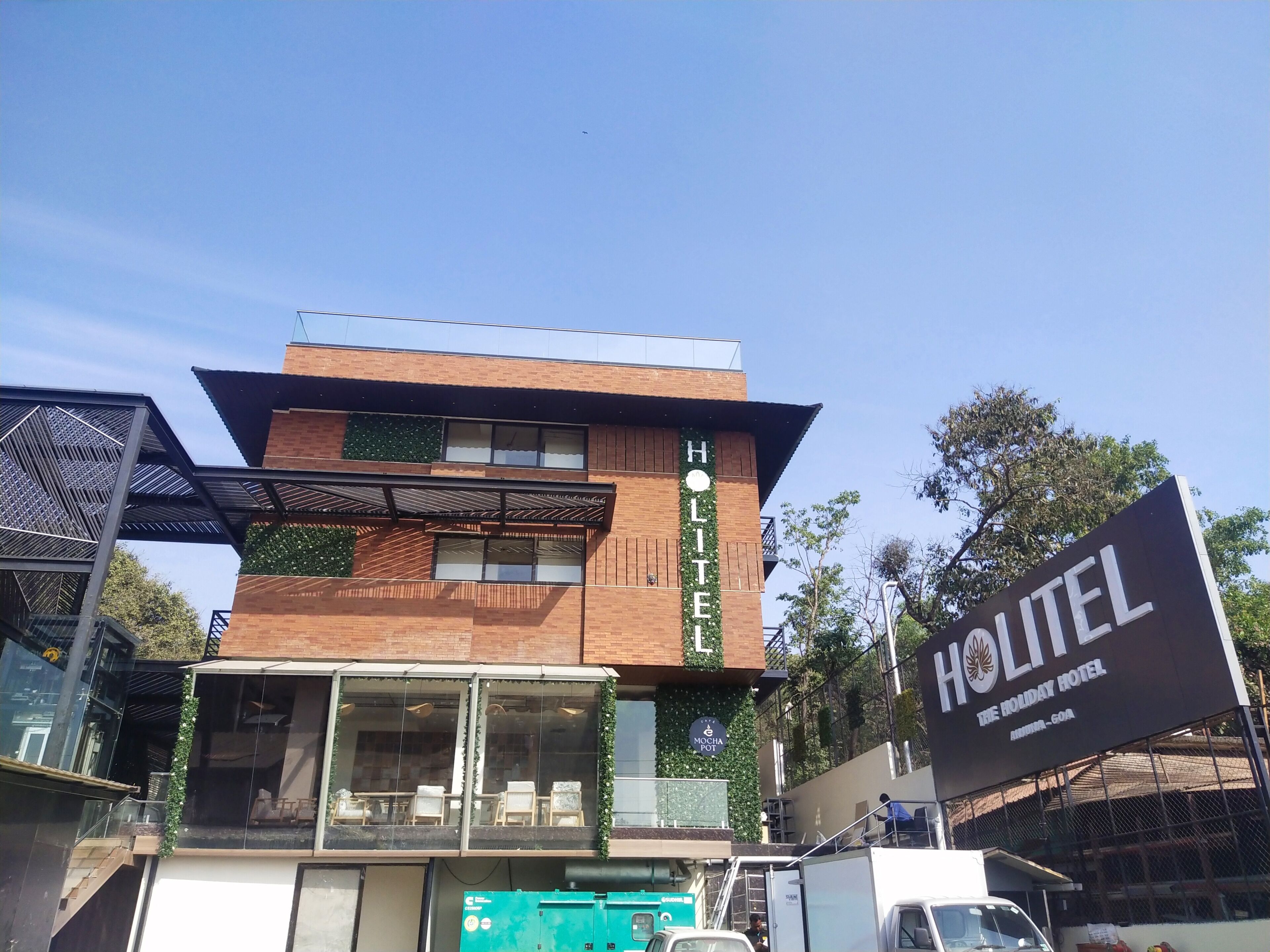 A modern hotel with a prominent sign reading "HOLITE HOTEL THE HOLIDAY HOTEL".