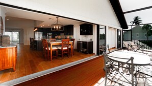 A spacious kitchen with wooden cabinets, a dining area with a table and chairs, and a view of the outdoors. - Private Riverfront Home - 1 mile to the Beach (Bonita Springs)