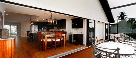 A spacious kitchen with wooden cabinets, a dining area with a table and chairs, and a view of the outdoors.