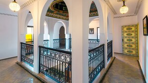 A grand hallway with ornate arches, a decorative ceiling, and a patterned floor. - Villa Leila Farmhouse  (marrakech)