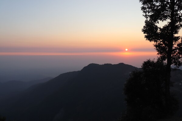 A mountain landscape at sunrise with a tree silhouette. - george evevest peak (Dehradun)