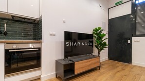 Une cuisine moderne dotée d’un four encastré, d’un meuble en bois et d’un téléviseur à écran plat posé sur un meuble en bois.