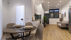 Un espace repas moderne avec une table ronde, des chaises et une vue sur la cuisine.