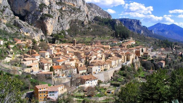 Une ville historique à l’architecture traditionnelle, avec des rues étroites et un paysage montagneux en toile de fond.