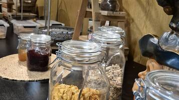 En køkkenbordplade med forskellige madvarer, herunder krukker med granola og andre ingredienser.