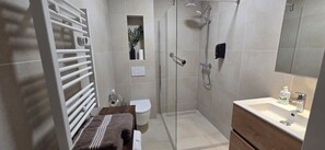 Habitación de lujo | Baño | Ducha, toallas, champú y papel higiénico