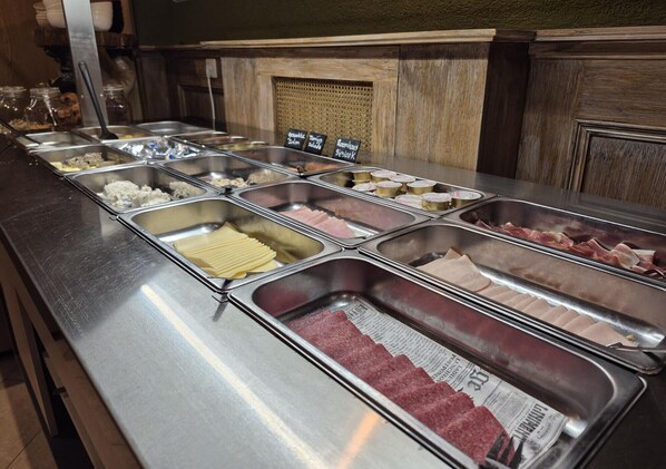 Un buffet proposant divers plats présentés dans des récipients en métal.