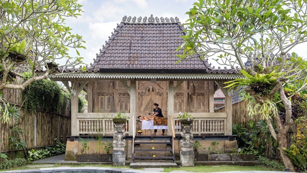 A traditional wooden structure with a tiled roof, a pool, and a person receiving a massage. - Wooden Ganeca Villas by GenuineHost (Tegallalang)