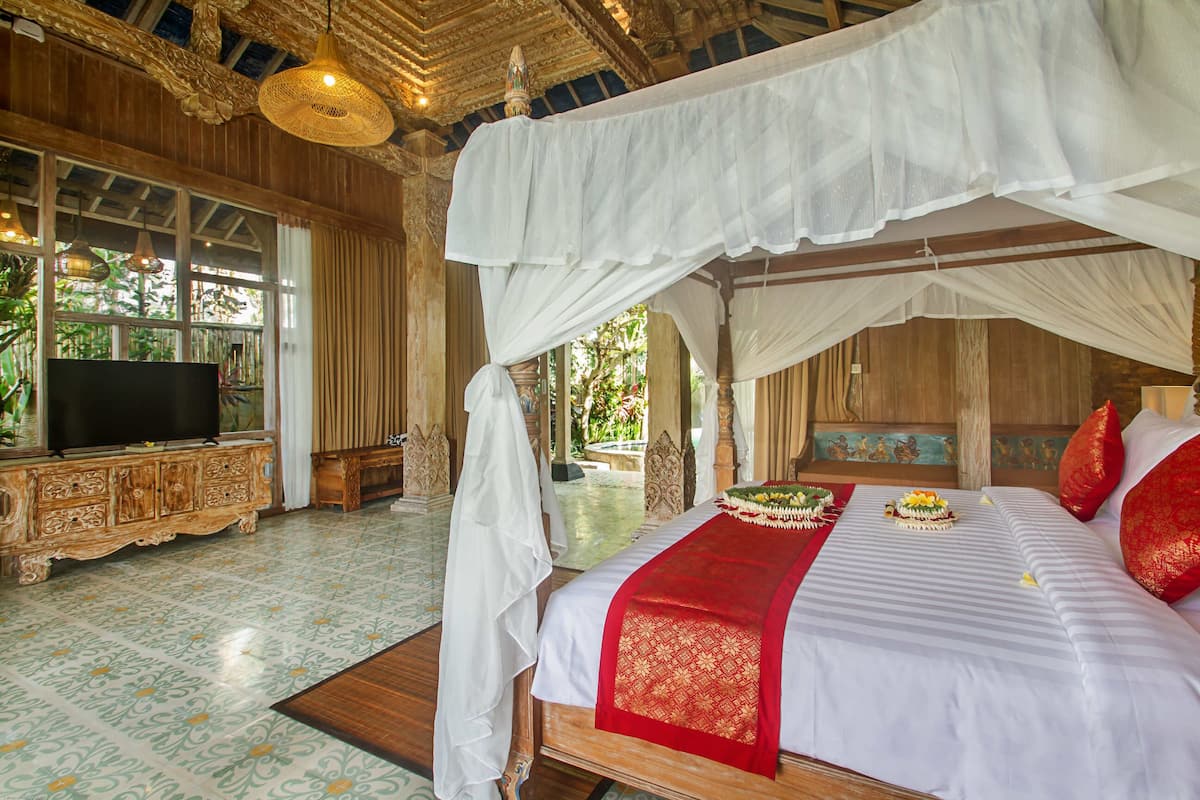 A room with a bed, TV, and a view of the outdoors.