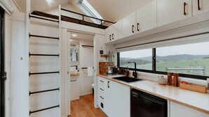 A modern kitchen with a large window, white cabinetry, and a built-in oven.