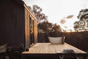 A wooden deck with a bathtub, a grill, and a hose. - Tiny Max - Daylesford & The Macedon Ranges (Merton)