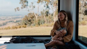 A person sitting by a window with a view of a landscape. - Tiny Ruby - Central West (Duramana)