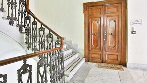 A staircase with ornate metal railings, a wooden door with a doormat, and a sign reading "Da Francesco". - Da Francesco (Naples)
