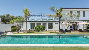 A modern house with a swimming pool, outdoor seating, and a well-maintained lawn. - Villa Hasian Jimbaran (Jimbaran)