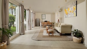 A modern living room with a sofa, coffee table, and dining area. - Villa Hasian Jimbaran (Jimbaran)