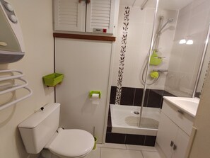 Ein kleines Badezimmer mit Toilette, Dusche und Waschbecken.