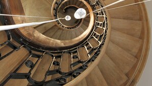 A spiral staircase with wooden steps and metal railings. - Manoir de Montigny (Russy-Bémont)