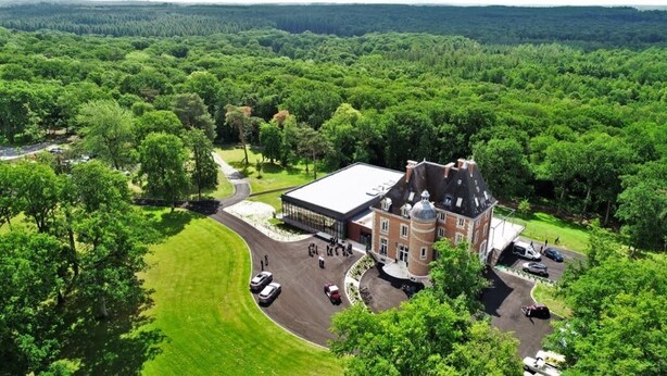 A large, historic building with a prominent tower and dome, surrounded by lush greenery and a well-maintained lawn. - Manoir de Montigny (Russy-Bémont)