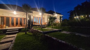 Une maison moderne avec une pelouse bien entretenue et un chemin menant à l’entrée.