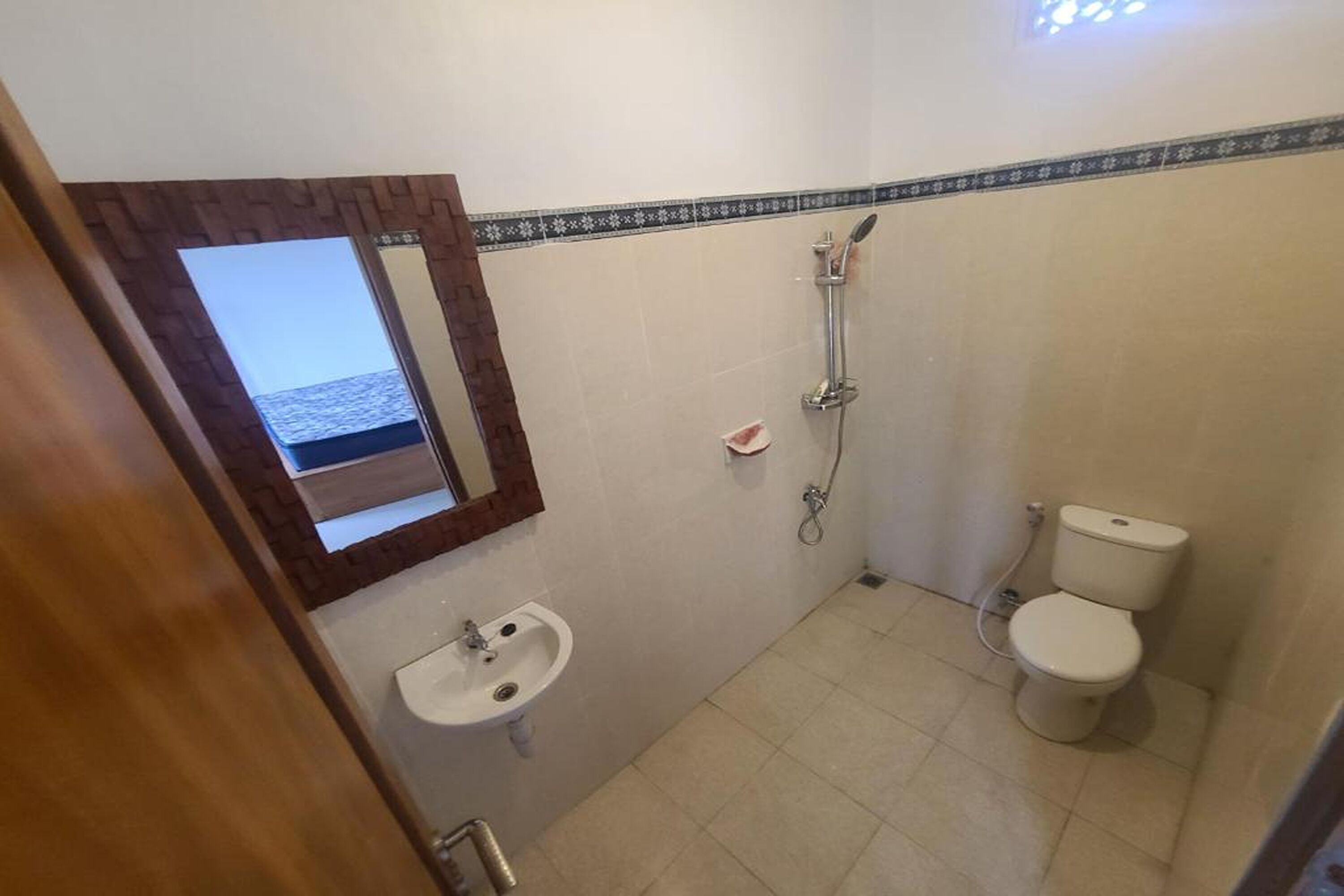 Et badeværelse med vask, toilet og brusebad.