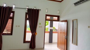 A room with two windows, a door, and an air conditioning unit. - Penginapan Bromo Lovero (Sukapura)