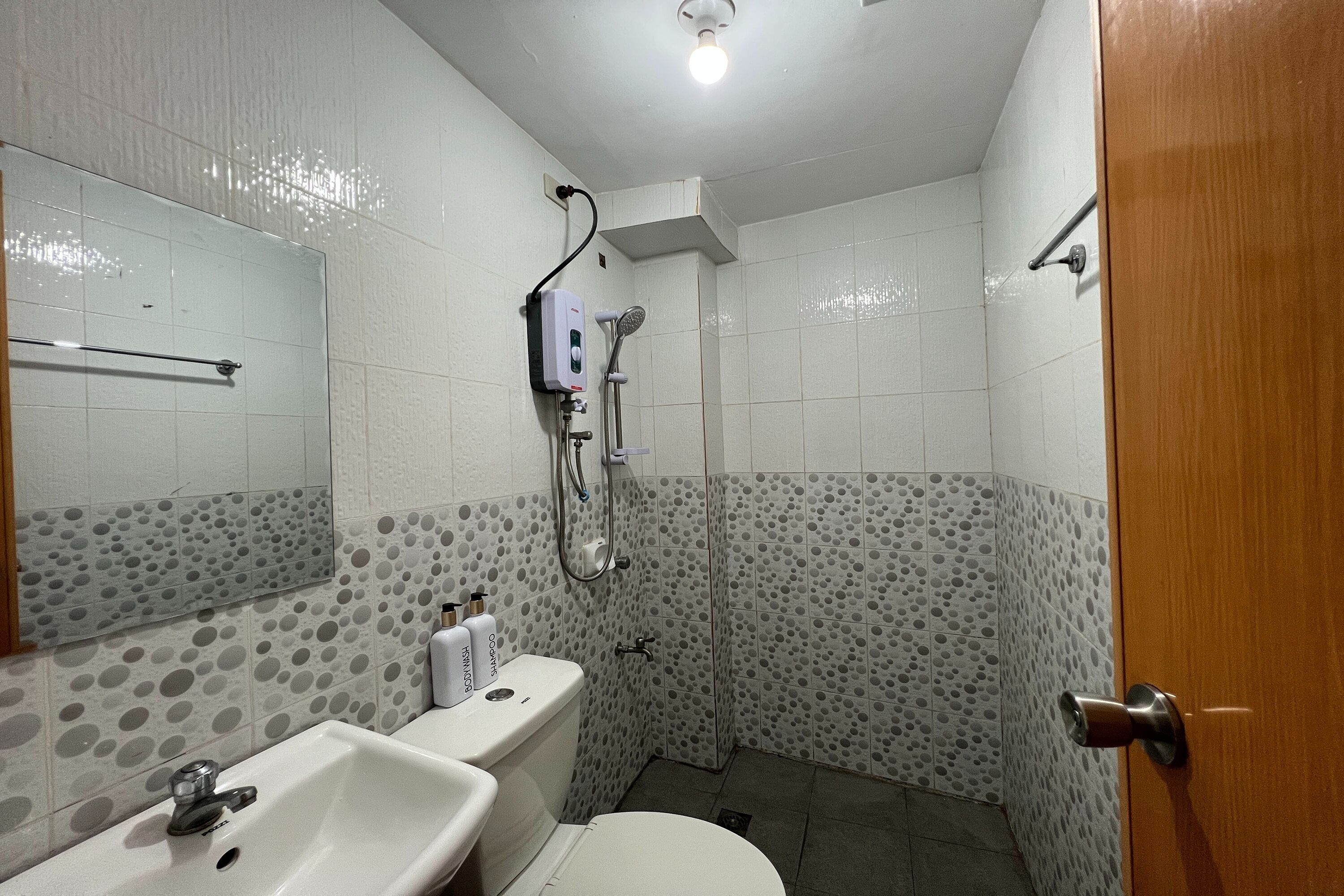 A bathroom with a toilet, sink, and shower.