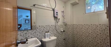 Un baño con inodoro, lavamanos y ducha.