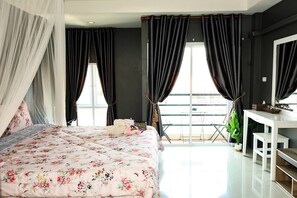 Quarto com cama, escrivaninha e varanda.