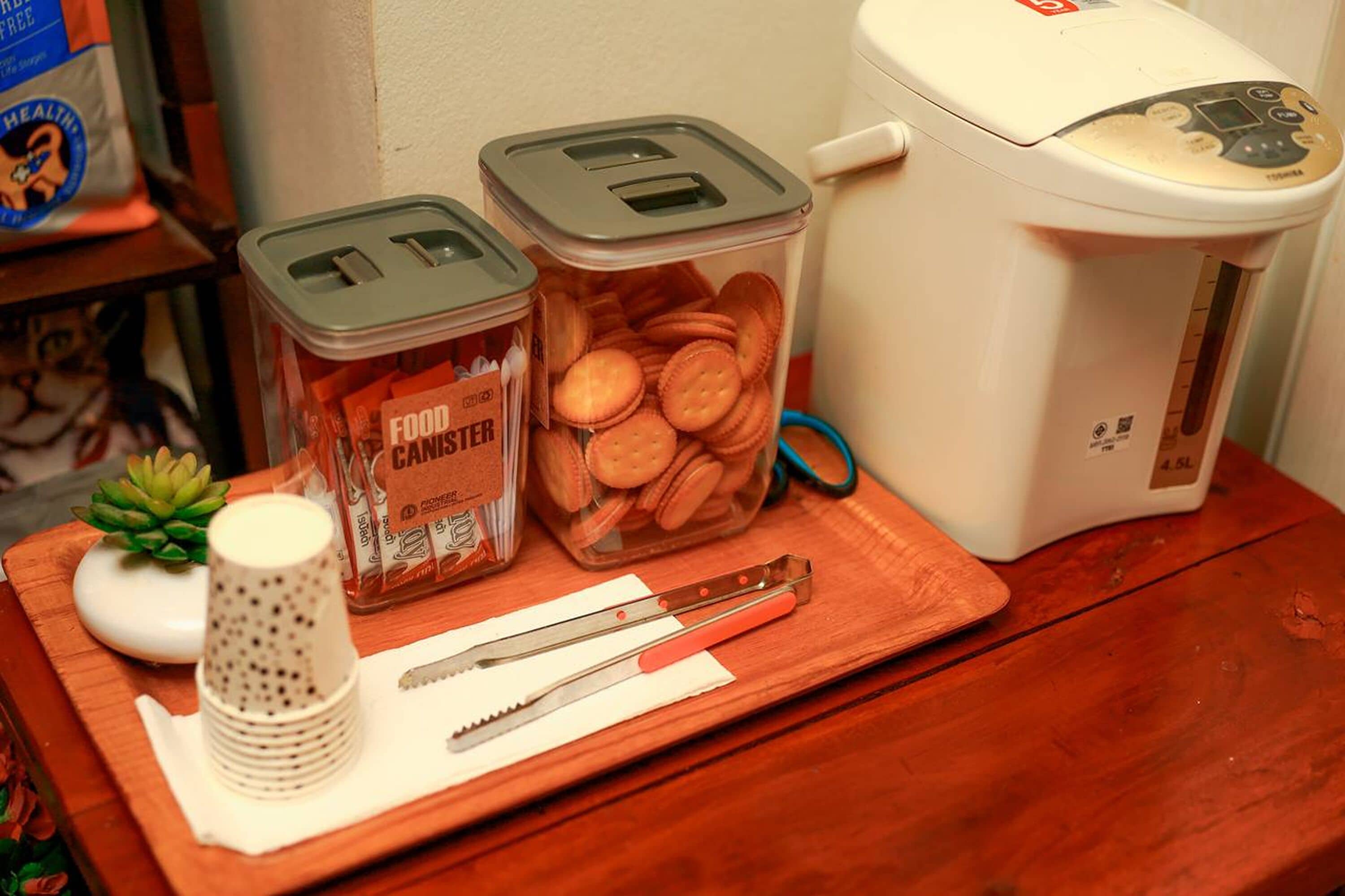 Una encimera de cocina con un procesador de alimentos, dos recipientes de comida, un rallador y un par de tijeras.