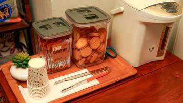 Una encimera de cocina con un procesador de alimentos, dos recipientes de comida, un rallador y un par de tijeras.