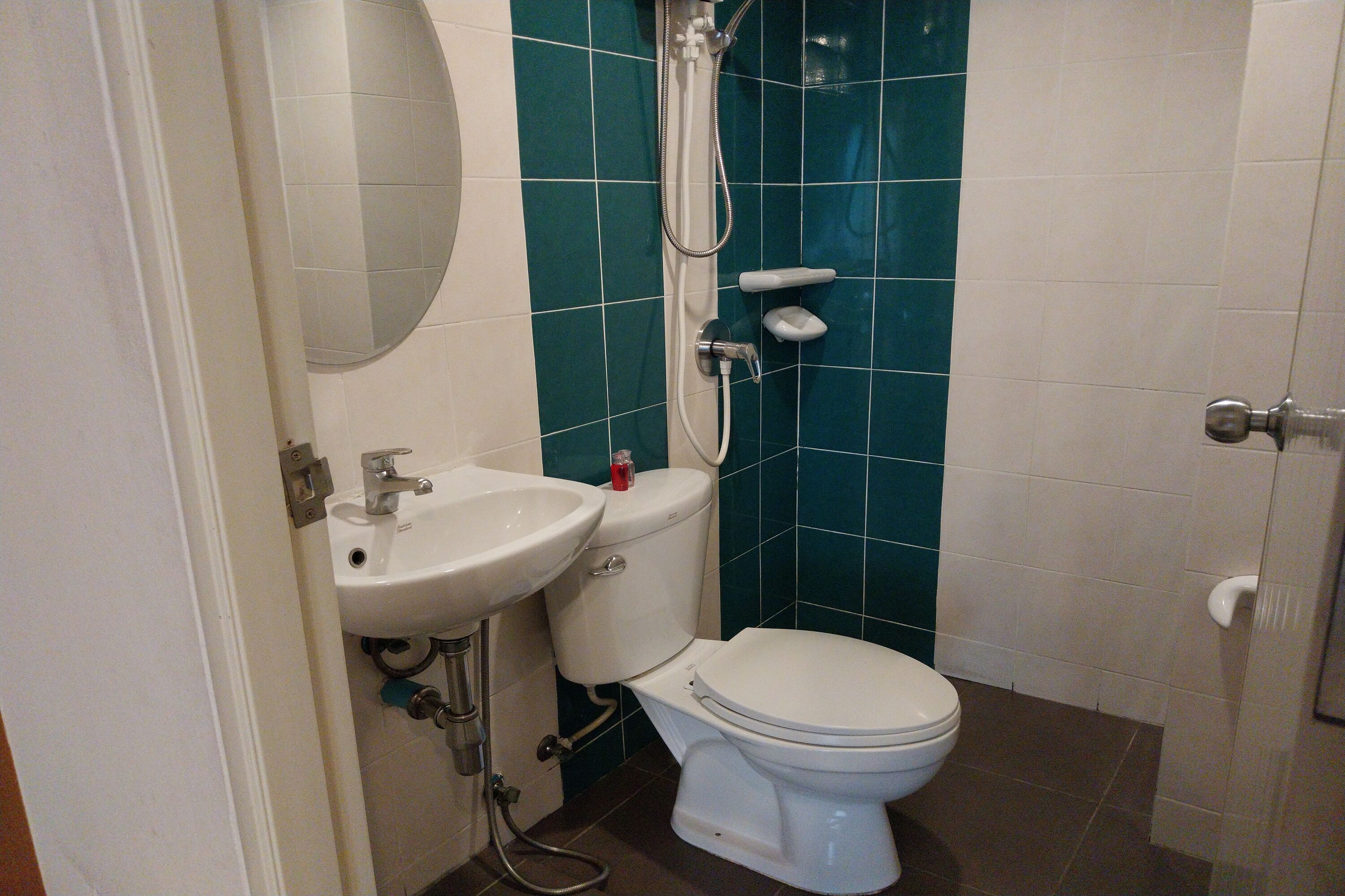 A bathroom with a white sink, toilet, and shower.