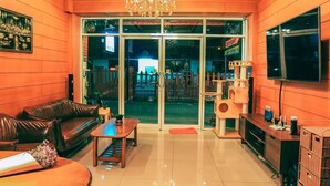 A modern interior with a leather sofa, a wooden coffee table, and a TV on a wooden cabinet. - Sleep Hotel (Chonburi)