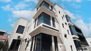 Un hotel moderno con un llamativo letrero 'HOTEL AP', amplias ventanas y un diseño limpio y contemporáneo.