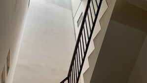 Una scala con ringhiera nera che porta a un pianerotto.