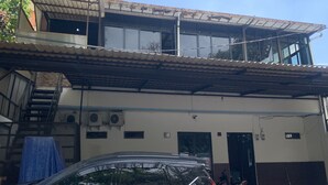 Un edificio a due piani con un'area di parcheggio coperta.
