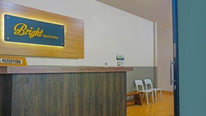 Una reception con un cartello che riporta "Bright Batavia". Si vedono sedie e un tavolino sullo sfondo.