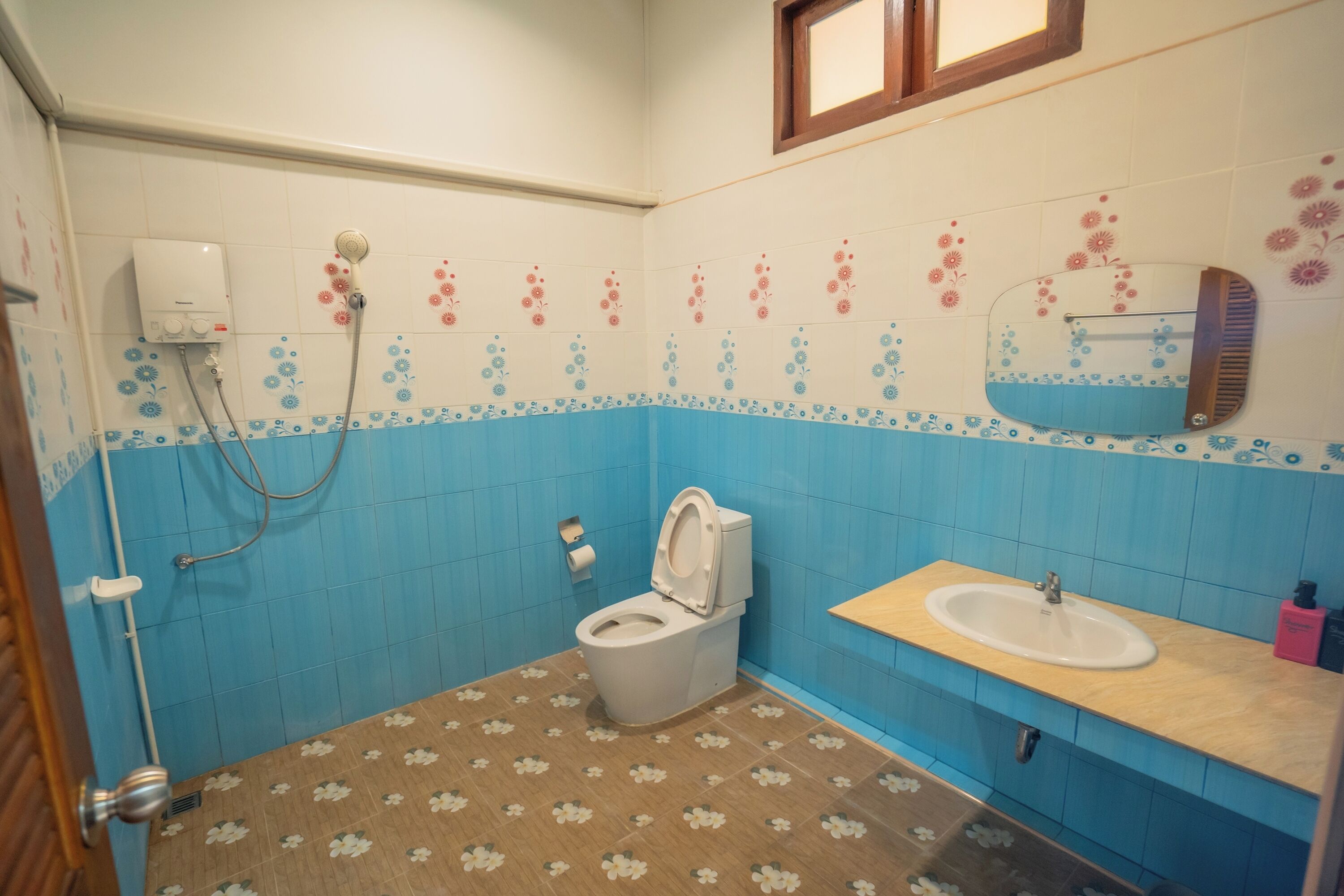 A bathroom with a toilet, sink, and shower.