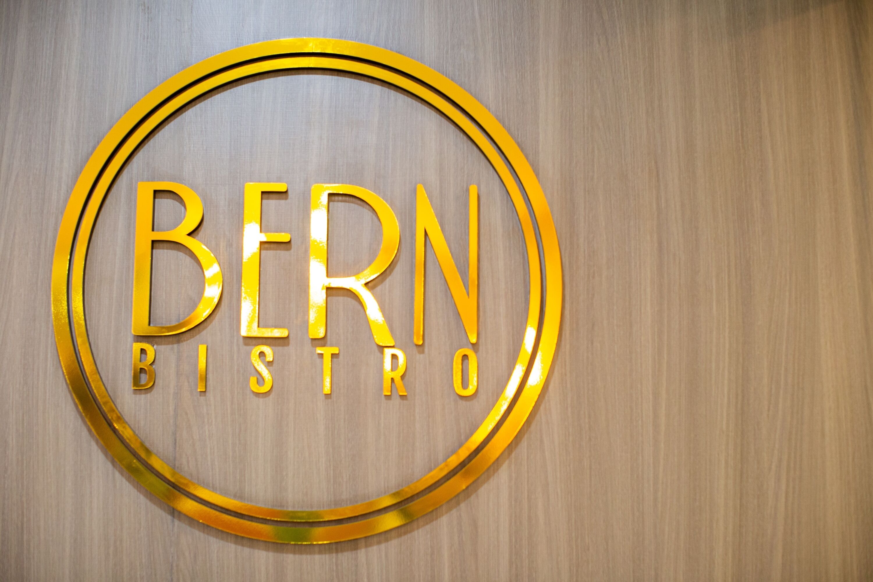 A circular sign with the words "BERN BISTRO" in a bold, golden font.