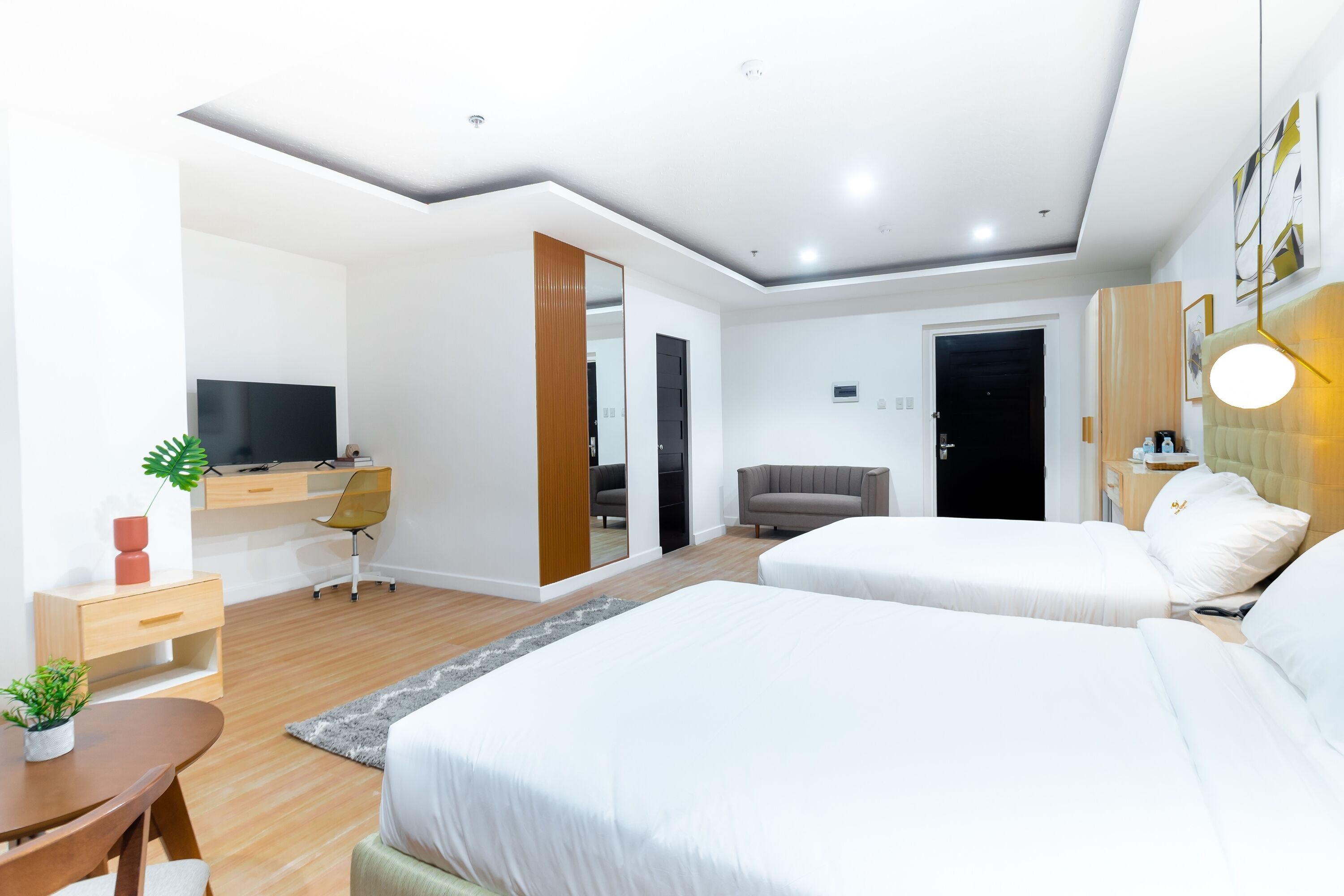 Een moderne hotelkamer met een groot bed, een bureau met stoel, een televisie en een spiegel.