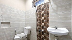 A bathroom with a toilet, shower, and sink. - R Residence (Medan)