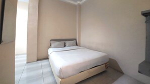 A bedroom with a bed, a window, and a door. - R Residence (Medan)