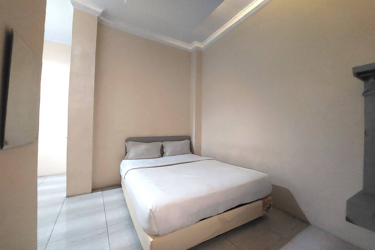 Ein Schlafzimmer mit Bett, Fenster und Tür.