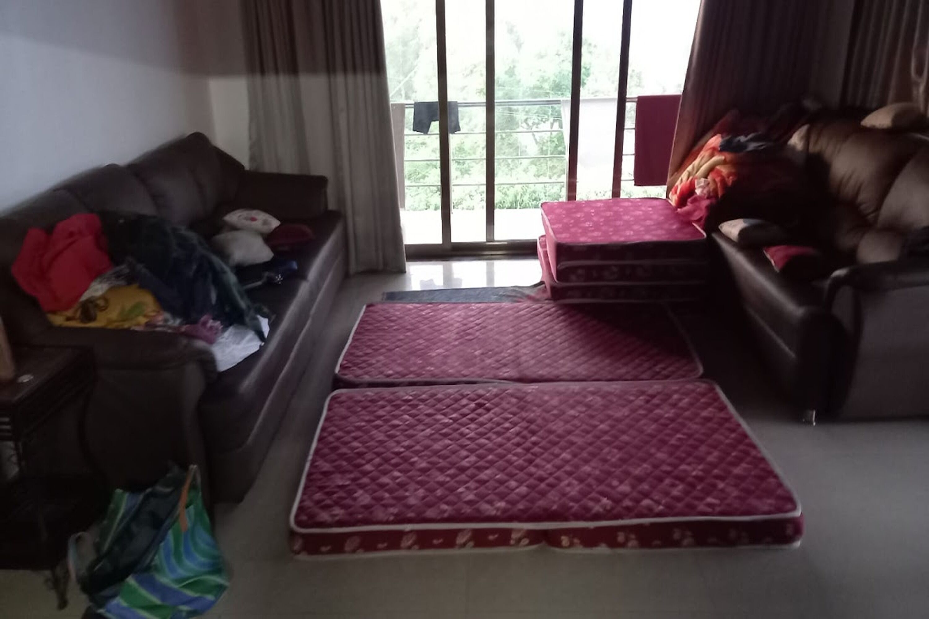 Uma sala de estar com um sofá, uma mesa de centro e uma janela grande.
