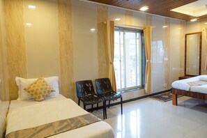 Una habitación de hotel con dos camas, una ventana con cortinas y un espejo.