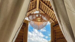 A wooden room with a thatched ceiling and a view of a water body outside. - Tiny ECO Bamboo Ubud (Sebatu)