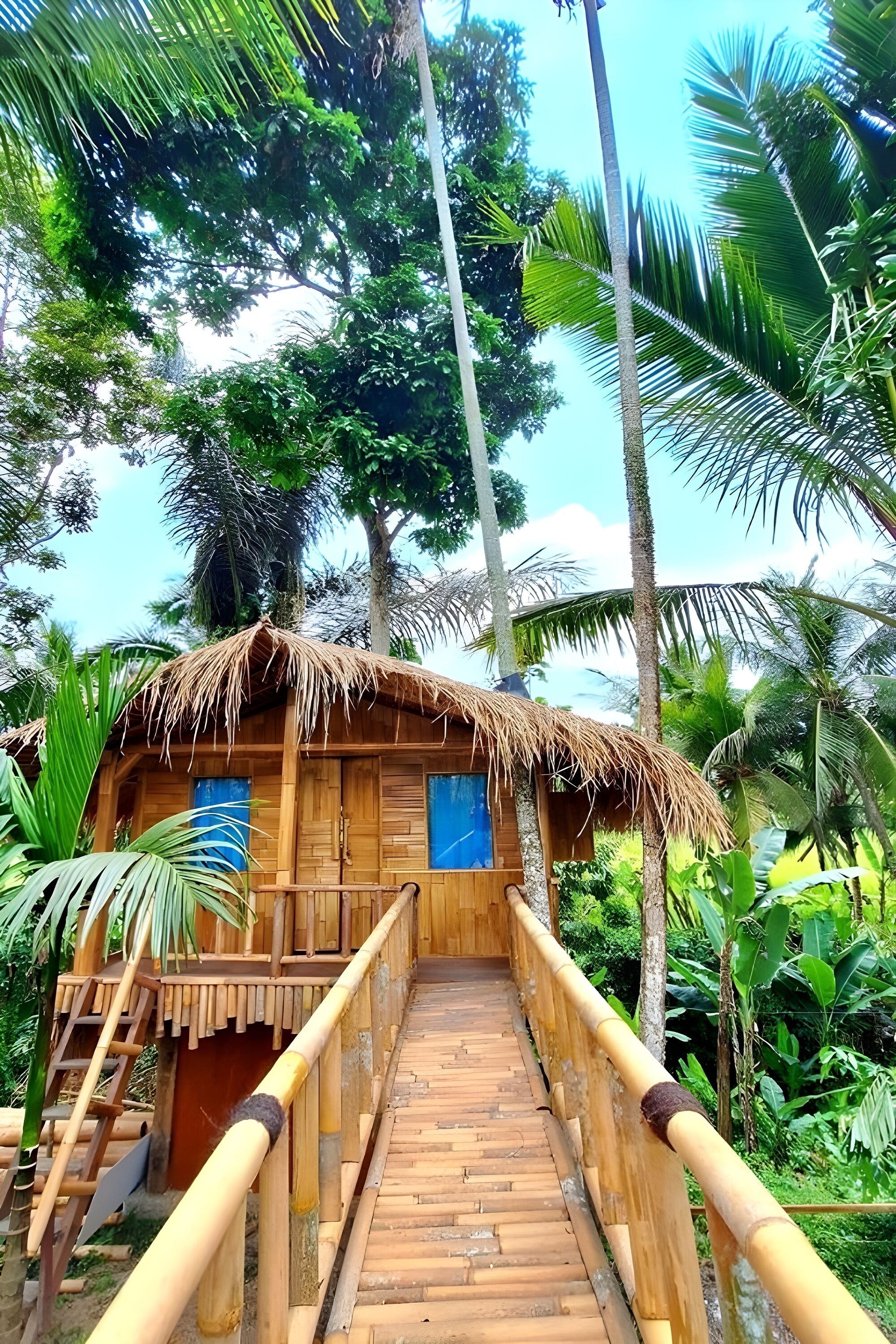 A wooden structure with a thatched roof, a wooden staircase leading to a door, and a wooden pathway with a railing.