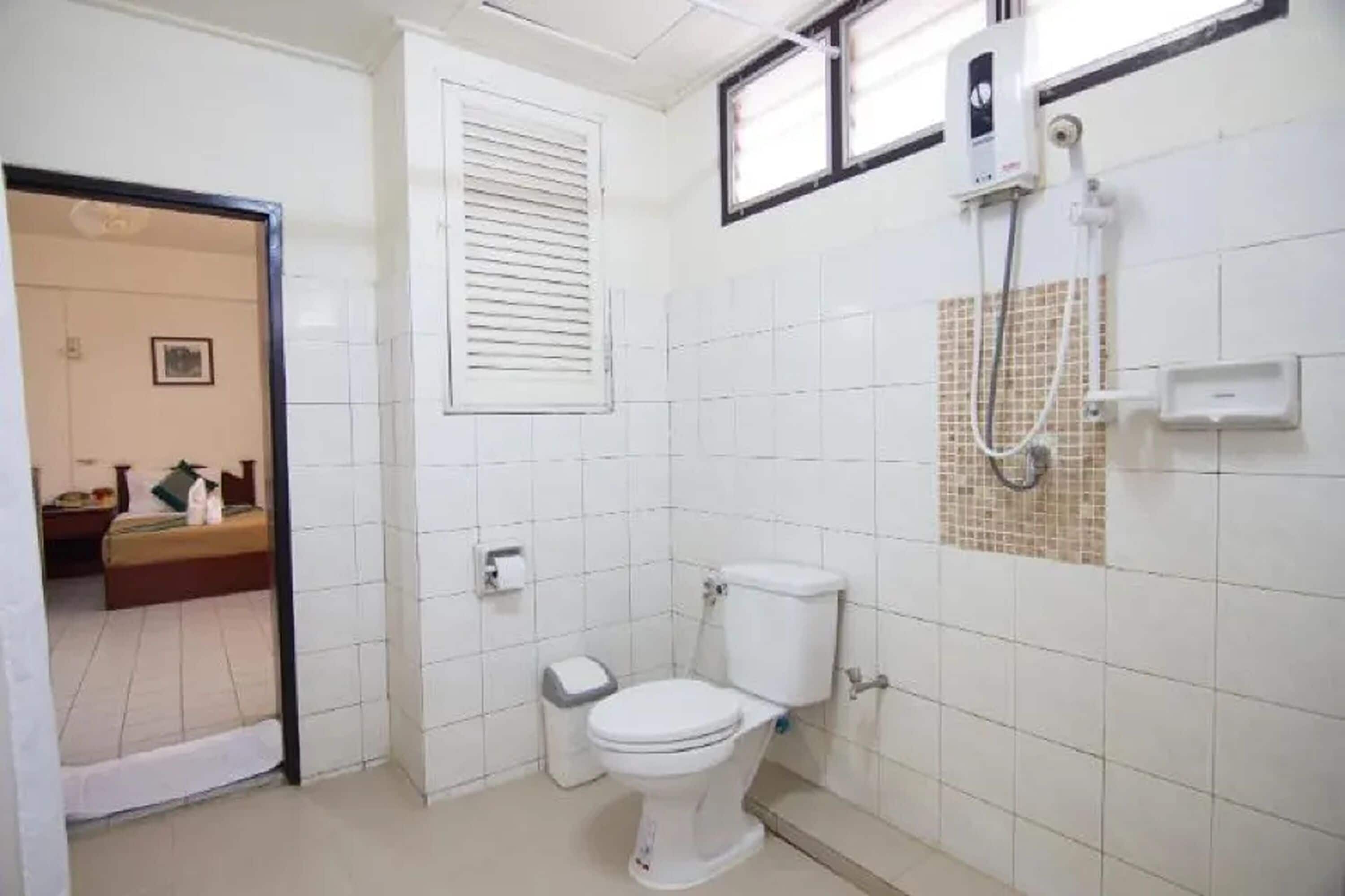 A small, clean bathroom with a toilet, a bidet, and a shower.