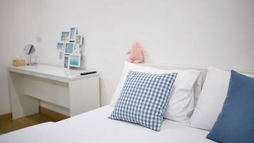 A neatly arranged bedroom with a bed, a bedside table, and a wall-mounted shelf.